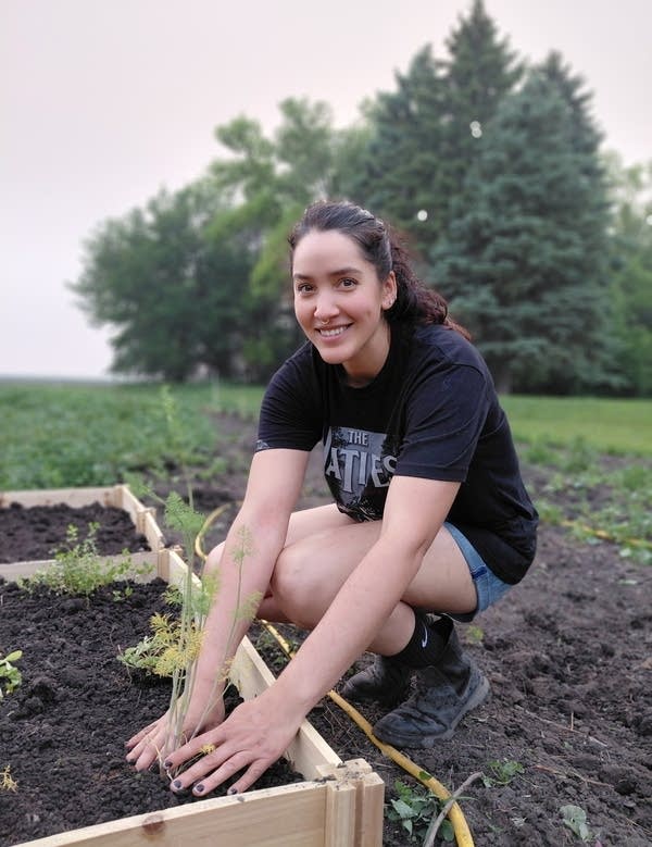 A woman sits a plants herbs