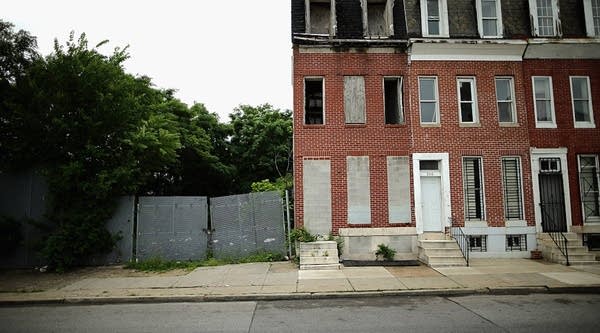 Cinderblocks wall off the door and windows of a burned and abandoned rowhouse across the street from First Mt Calvary Baptist Church, in the Winchester-Sandtown neighborhood June 15, 2015 in Baltimore, Maryland. 