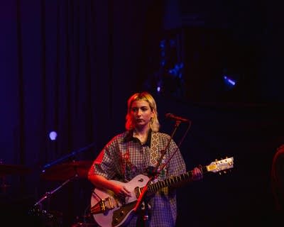 A woman plays a guitar.