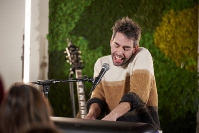 A man sings and plays keyboards onstage