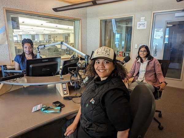 three people smiling in a radio studio