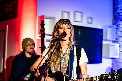 A musician sings and plays guitar onstage