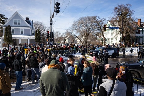 A crowd gathers at the scene of a shooting