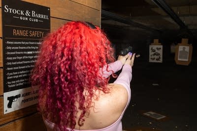 A woman holds a gun
