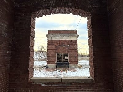 Looking through an opening toward a brick building