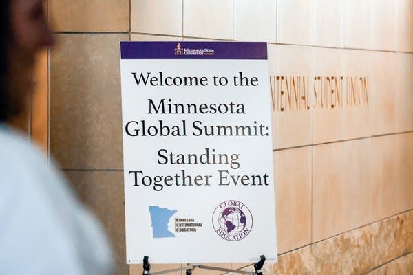 A poster reads, "Welcome to the Minnesota Global Summit: Standing Together Event."
