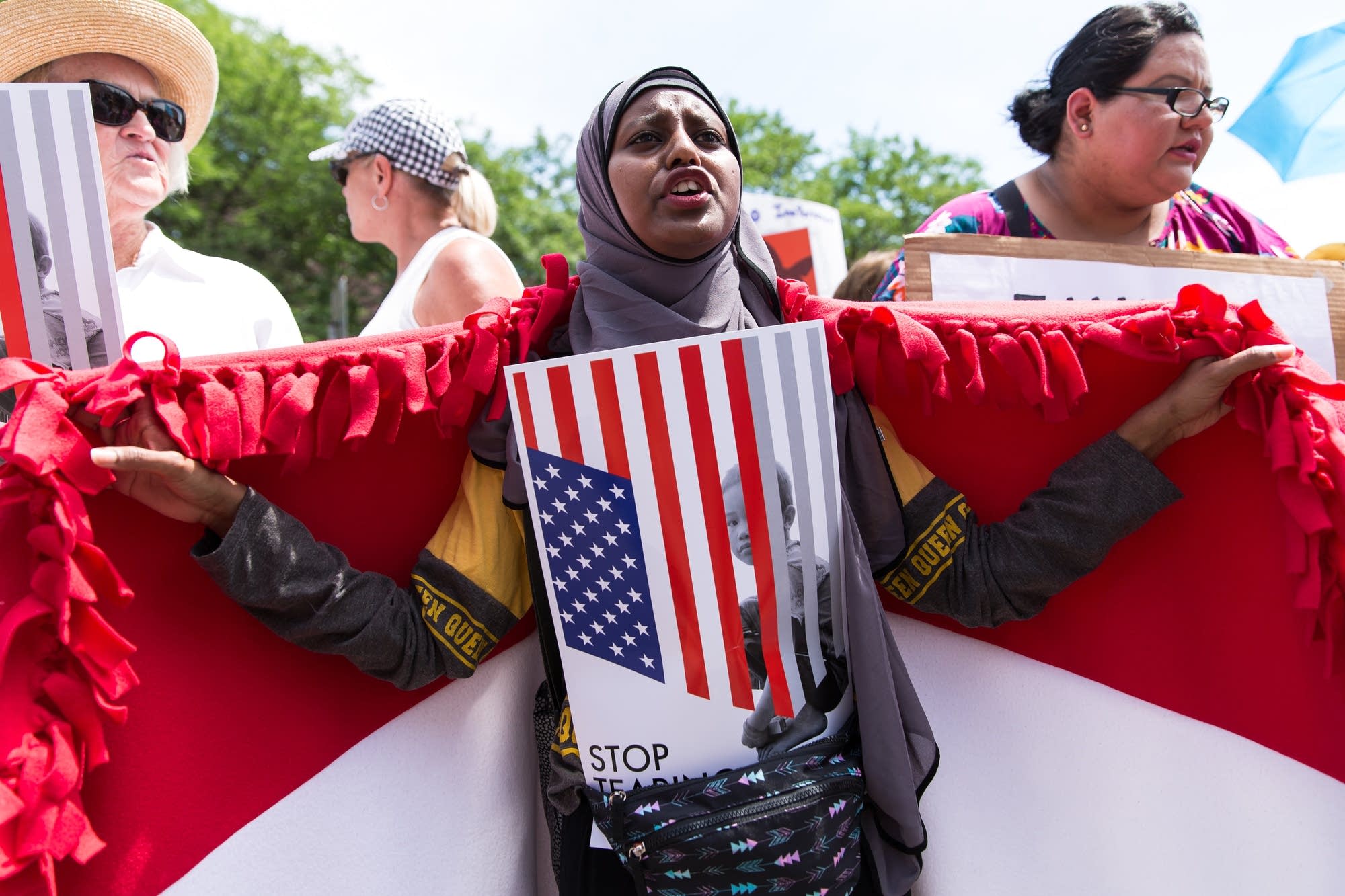 22-year-old Zaynab Abdi, a refugee from Yemen, holds up her country's flag.