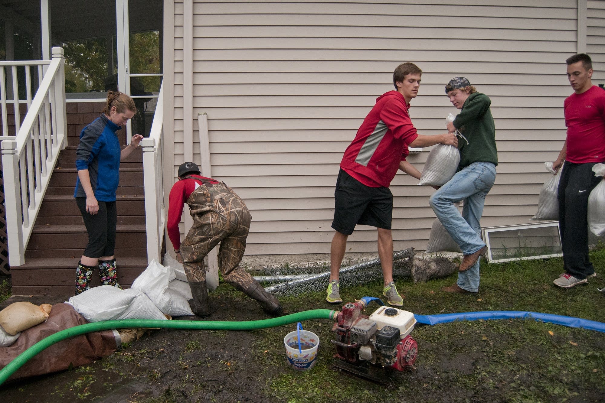 Volunteers help Sarah Rossi sandbag her house.