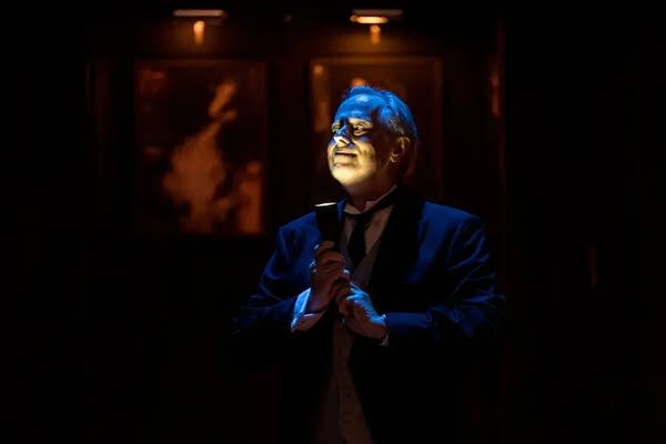 a man stands with a flashlight under his face