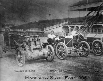 A black and white photograph of vehicles at a race.