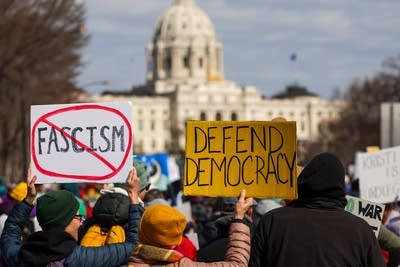 People hold signs at a protest