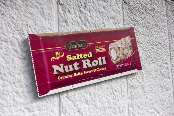 A sign showing the packaging for Pearson's The Original Salted Nut Roll candy.