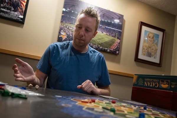 A man rolls two dice at a table