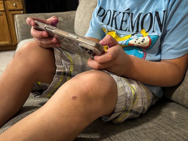A boy plays games on a phone