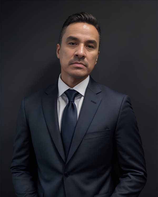 A man poses for a photo in a suit