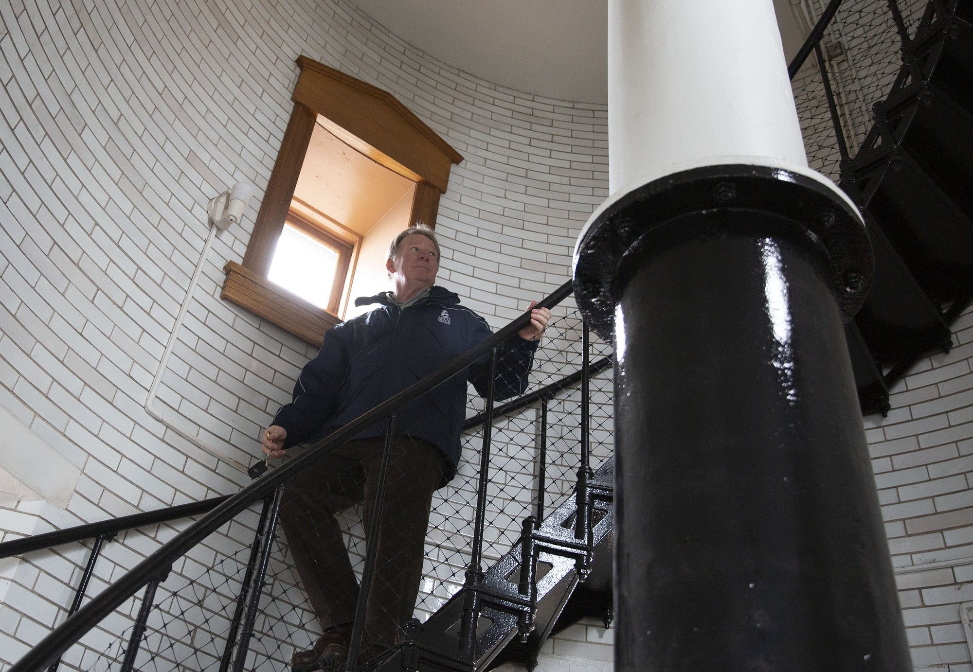 Lee Radzak climbs down spiral steps inside Split Rock Lighthouse.