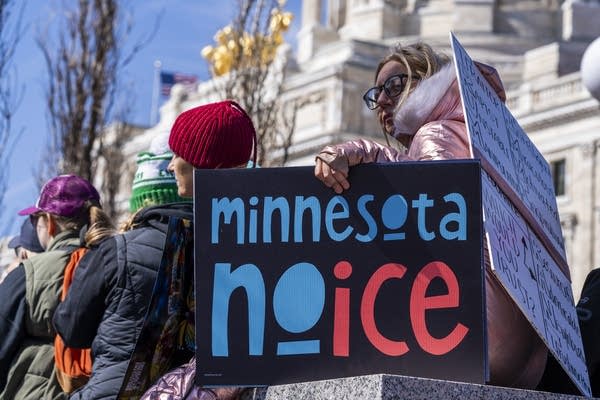 Someone holds a sign that says Minnesota No Ice