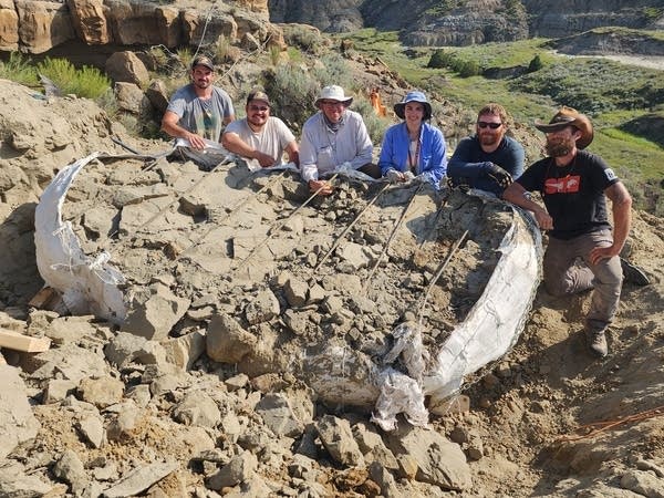 Paleontologists pose with fossil