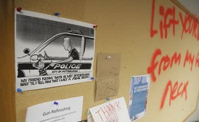 A bulletin board is sprayed with graffiti inside the 3rd Precinct building