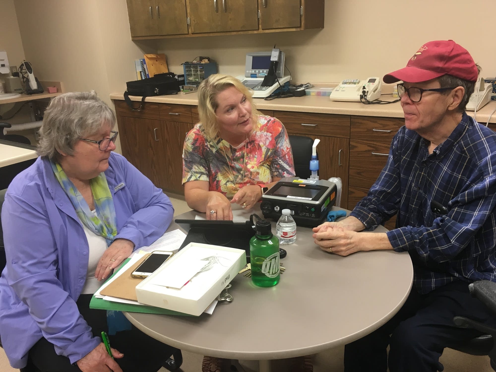Jolene Hyppa-Martin shows Richard and Peggy Harri how to use an iPad.