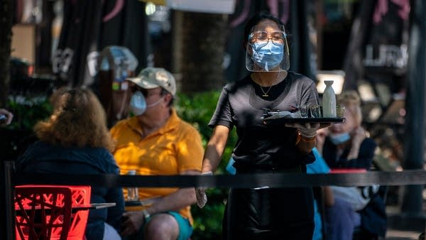 A server wearing protective gear at work in a Maryland restaurant.