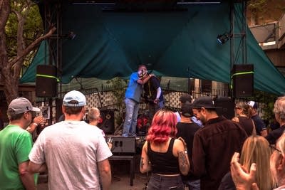Two men hugging on stage and crowd watching
