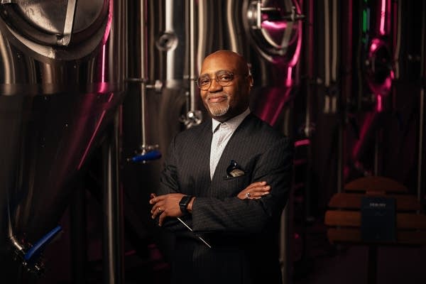 man in tux stands by brewery tanks