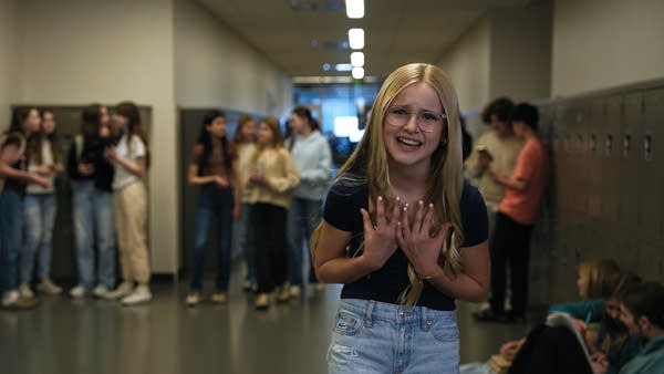 A musician performs in a school hallway.