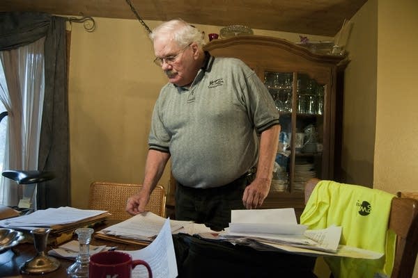 Rollie Norton looks through stacks of papers