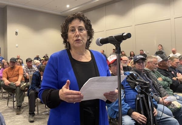 A woman in a blue shirt talks