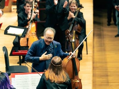 Two musicians exchange greetings onstage