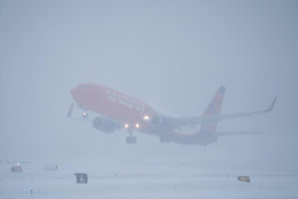 A plane takes off during a snow storm