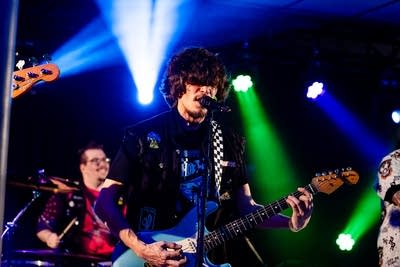 A musician sings and plays guitar onstage