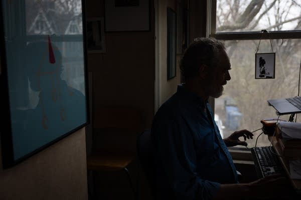 A man is silhouetted in his office