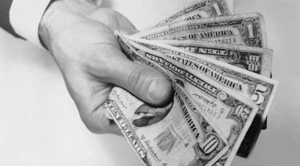 UNITED STATES - CIRCA 1950s: Hand holding out money.