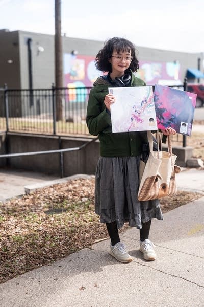 A person holds up recently purchased records at a record store