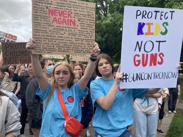 Two students hold protest signs 