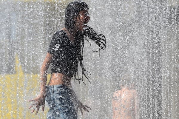 A girl plays in water in central London