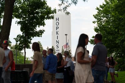 The Hopkins water tower is seen in the distance behind a crowd of mourners at a vigil.