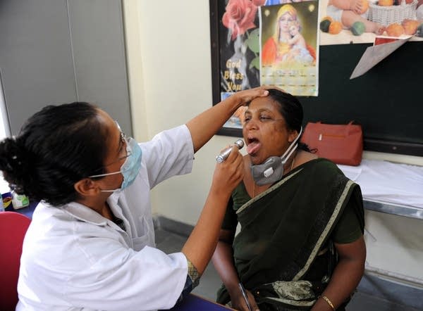 An Indian doctor examines a school teach