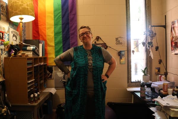 A person stands in their office for a photo