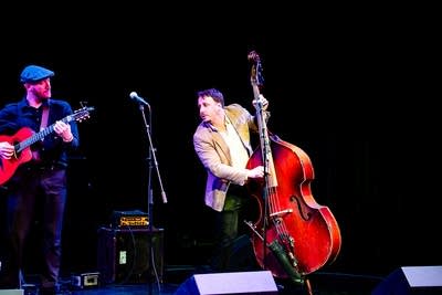 Two musicians perform together onstage