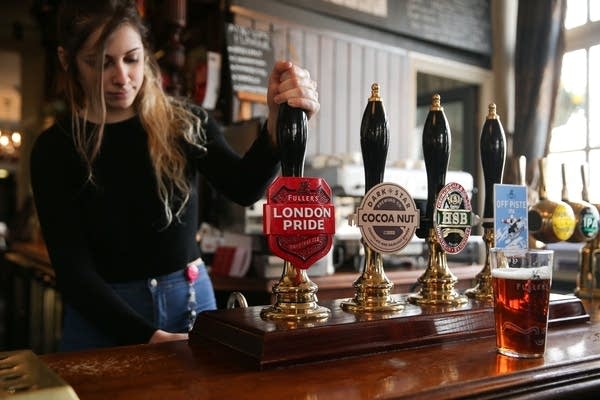 A bartender is pictured as she pulls a pint of Fuller's London Pride beer in a pub next to the Fuller's Griffin Brewery in Chiswick, west London. (Photo credit should read DANIEL LEAL-OLIVAS/AFP/Getty Images)