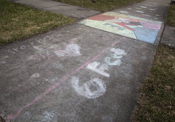 Words written in chalk on the sidewalk. 