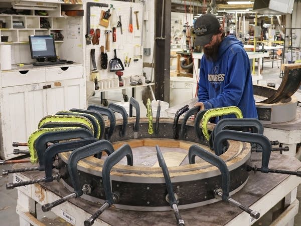 a worker places clamps on wood