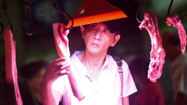 A customer checks pork meat at a market in Hangzhou in China's eastern Zhejiang province on September 10, 2019.