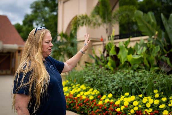 A woman stands next to a garden