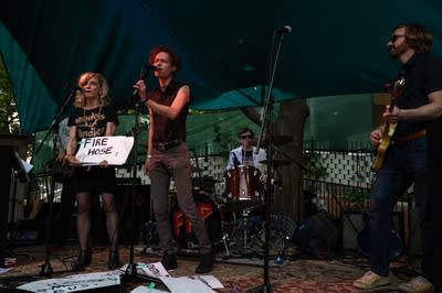 A rock band performing on an outdoor stage