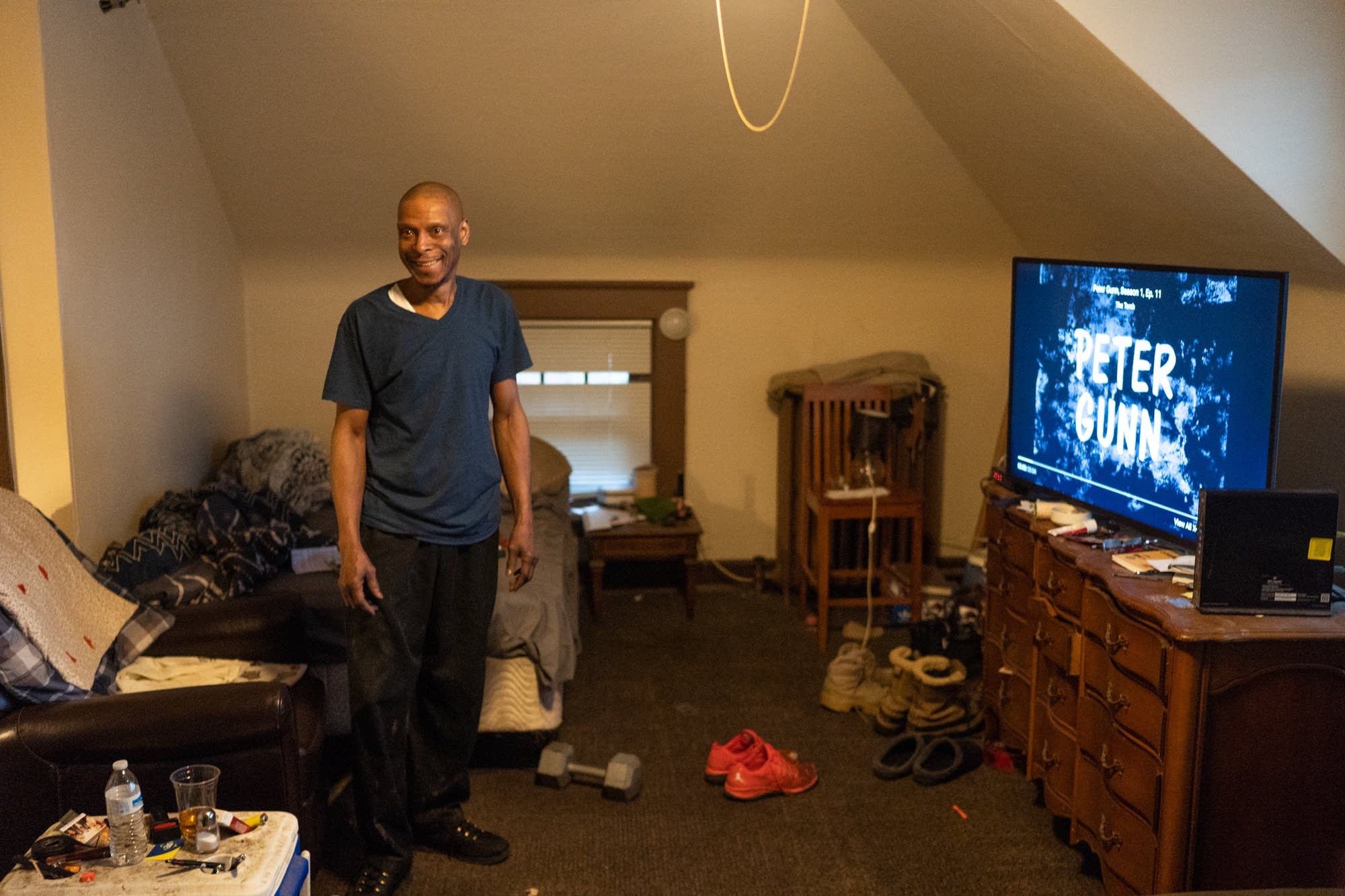 Craig Spivey stands in his studio apartment inside of a rooming house