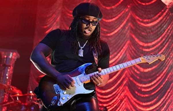 leon thomas playing guitar on stage